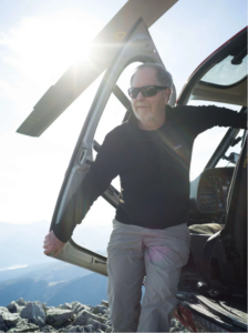 Ecologist Dr. Eric Higgs exiting a helicopter during fieldwork